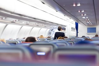 Airplane cabin interior with flight attendant