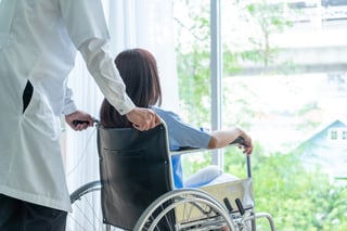 Professionnel de santé aidant un patient en fauteuil roulant
